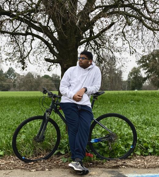 A student standing in front of a bike