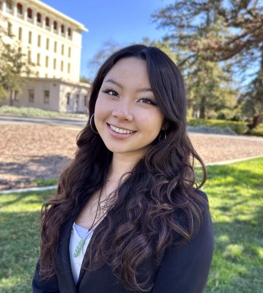 Emma Pham smiling in a grassy lawn