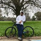 A student standing in front of a bike
